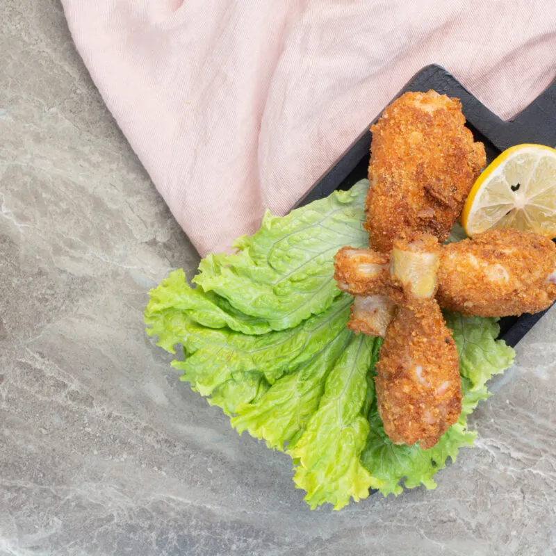 chicken-crispy-legs-with-lettuce-lemon-dark-board-scaled-300x300