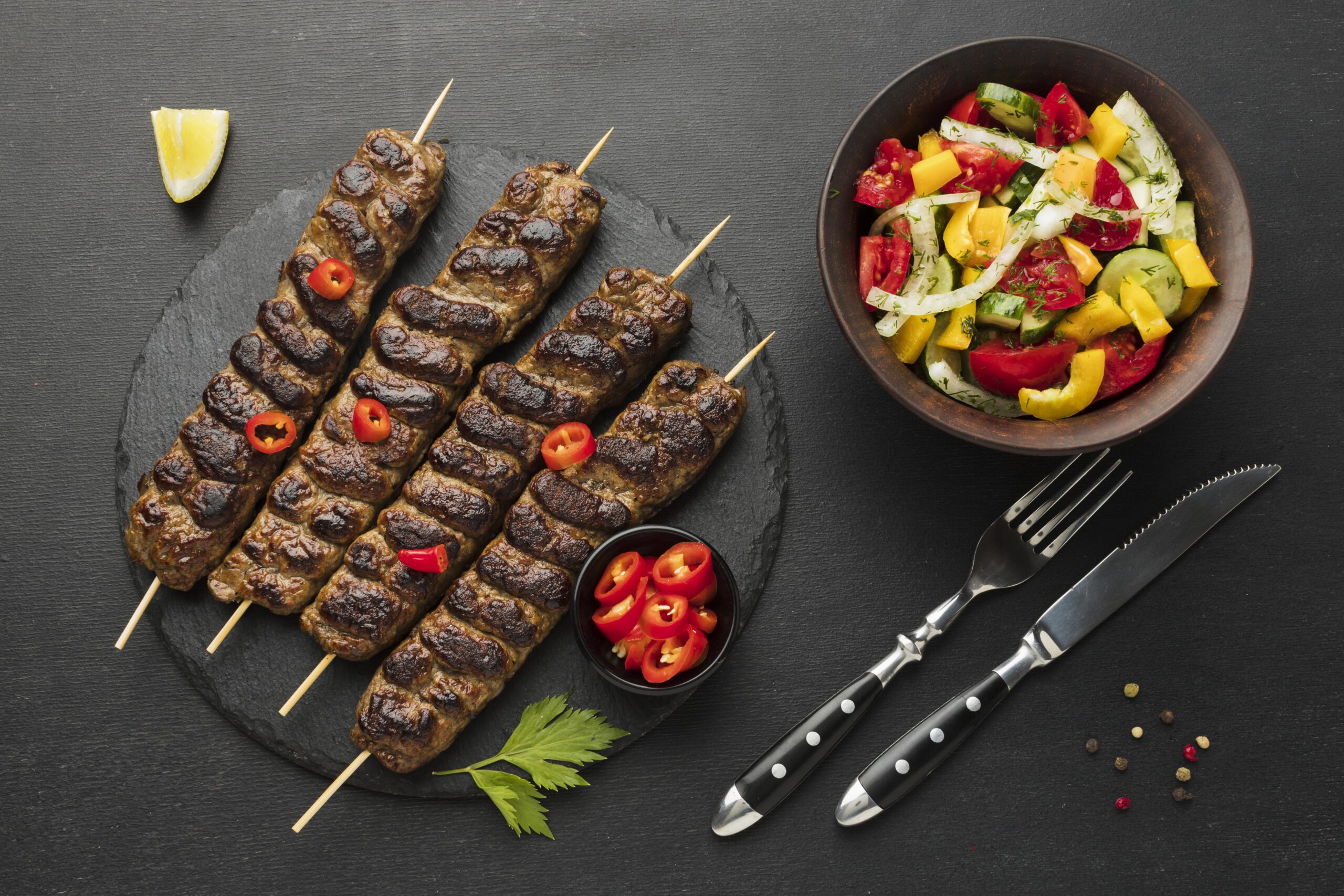 flat-lay-tasty-kebab-slate-with-other-dish-cutlery