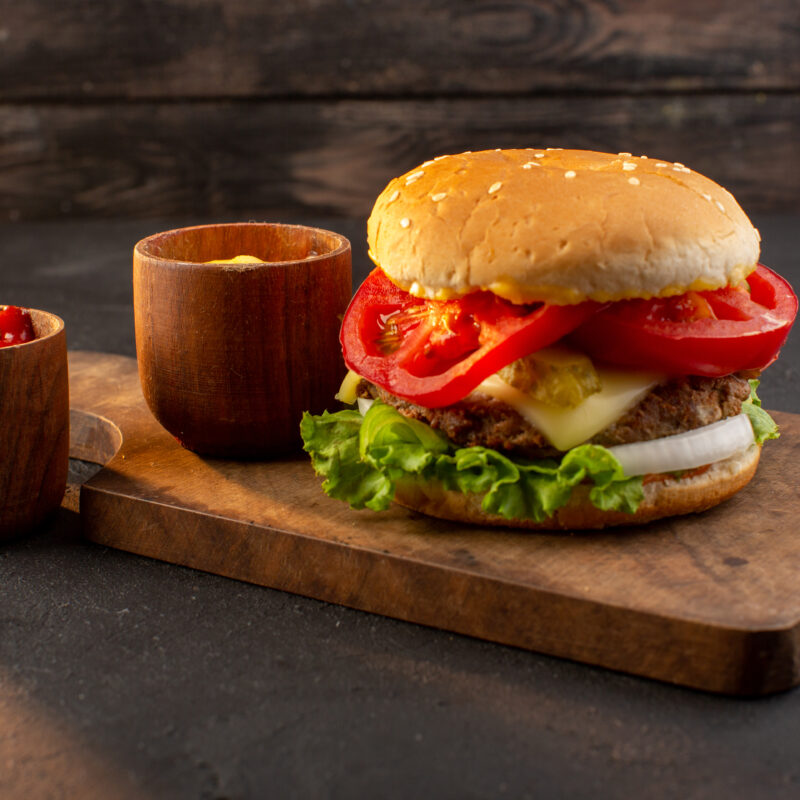 front-view-chicken-burger-with-cheese-green-salad-wooden-desk-sandwich-fast-food-meal