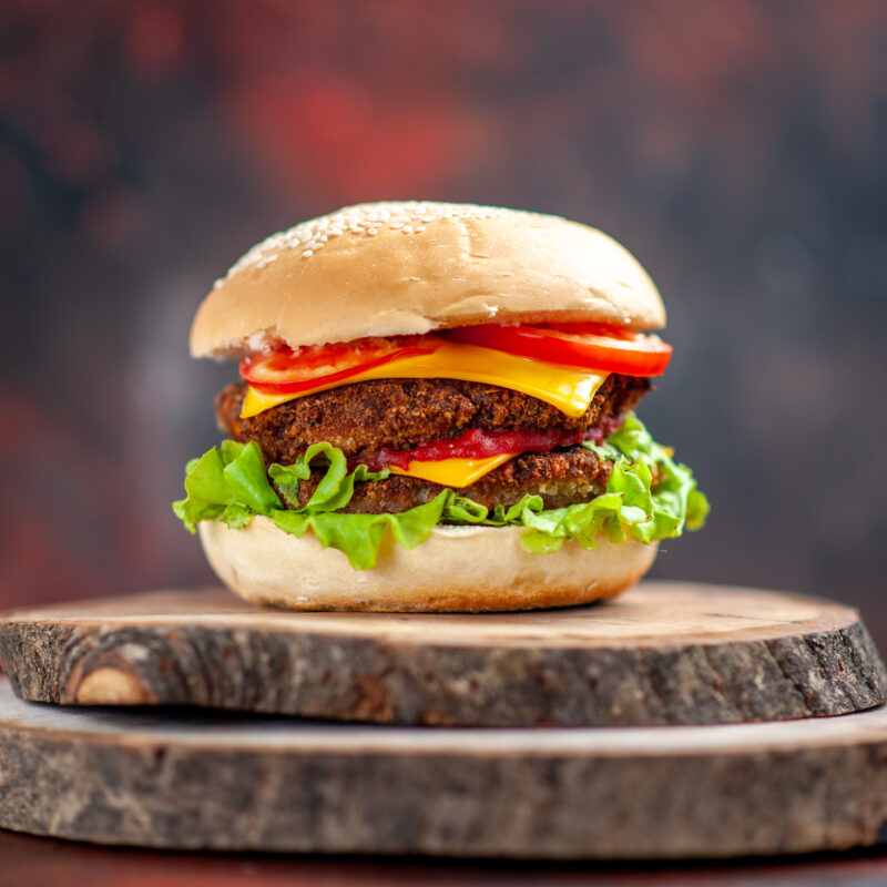 front-view-meat-burger-with-salad-cheese-tomatoes-dark-background