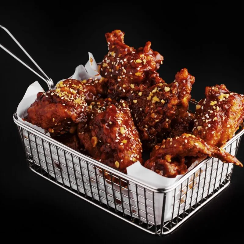 high-angle-shot-basket-delicious-fried-chicken-with-hot-sauce-black-surface-scaled-300x300