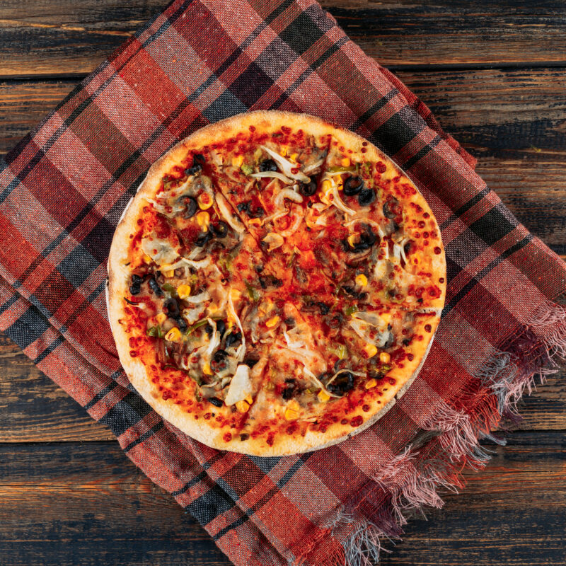 Pizza on dark wooden and picnic cloth background