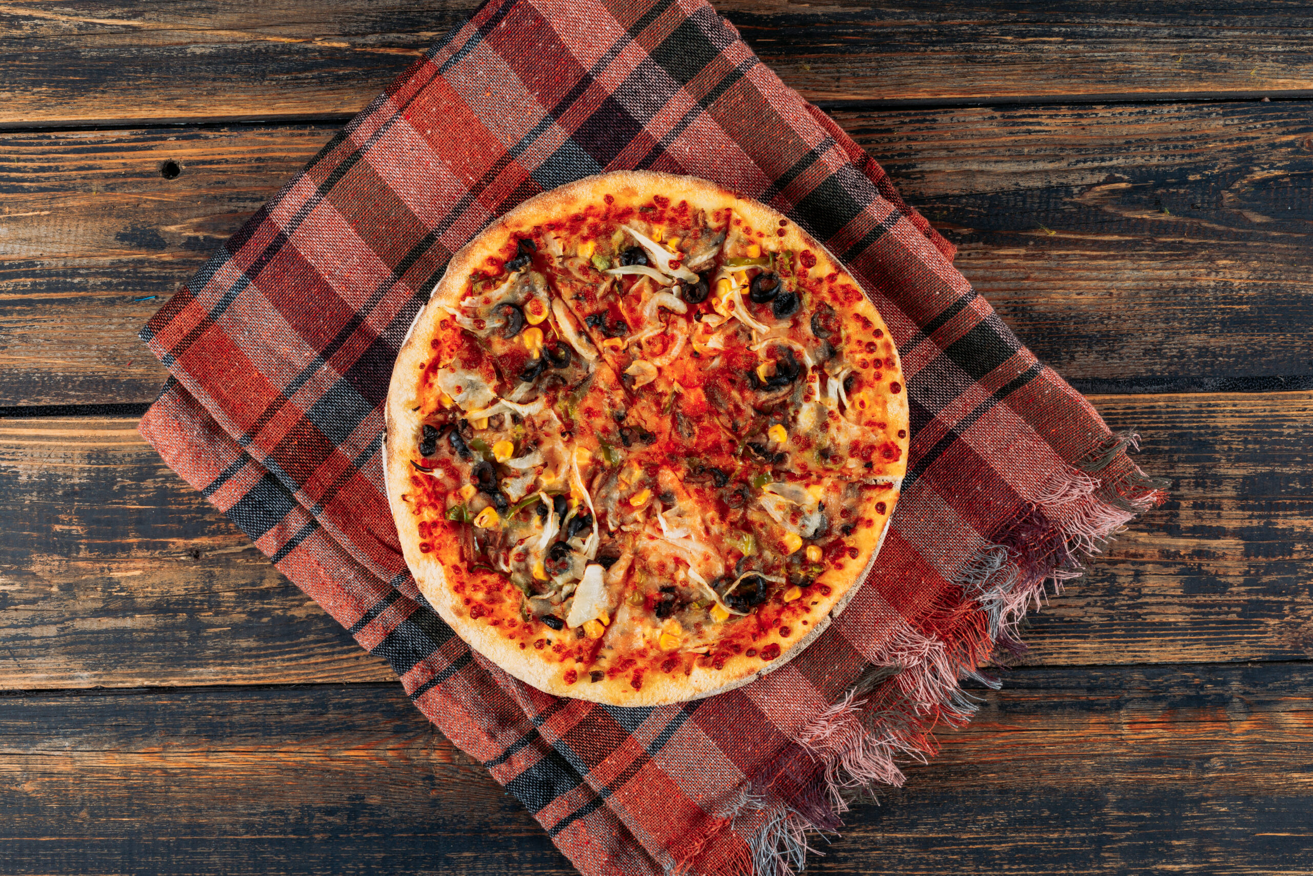 Pizza on dark wooden and picnic cloth background