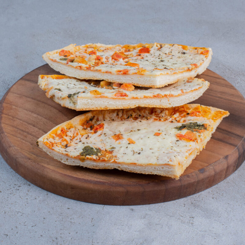 Pizza slices on a wooden board on marble background