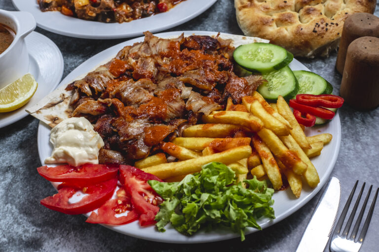 side-view-doner-plate-with-french-fries-tomato-fresh-cucumber-yogurt-bread-table (1)