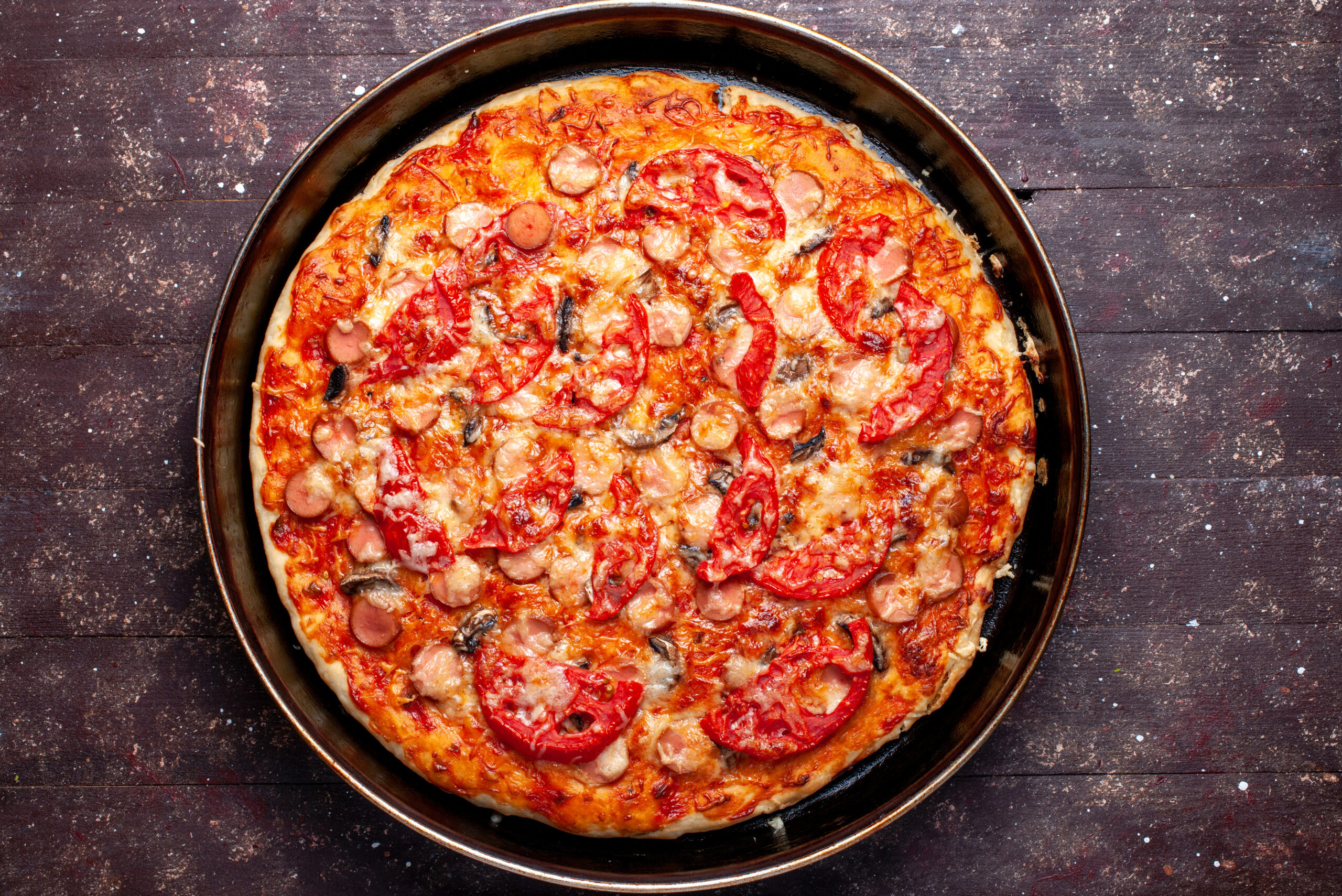 top-view-cheesy-tomato-pizza-with-olives-sausages-inside-pan-brown-desk-pizza-food-meal-fast-food-cheese-sausage