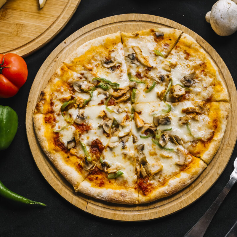 top view of chicken pizza with green bell pepper mushroom cheese and tomato sauce