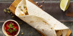 burrito-cutting-board-near-tomato-sauce-sliced-lime-cardamom-seeds
