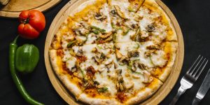 top view of chicken pizza with green bell pepper mushroom cheese and tomato sauce